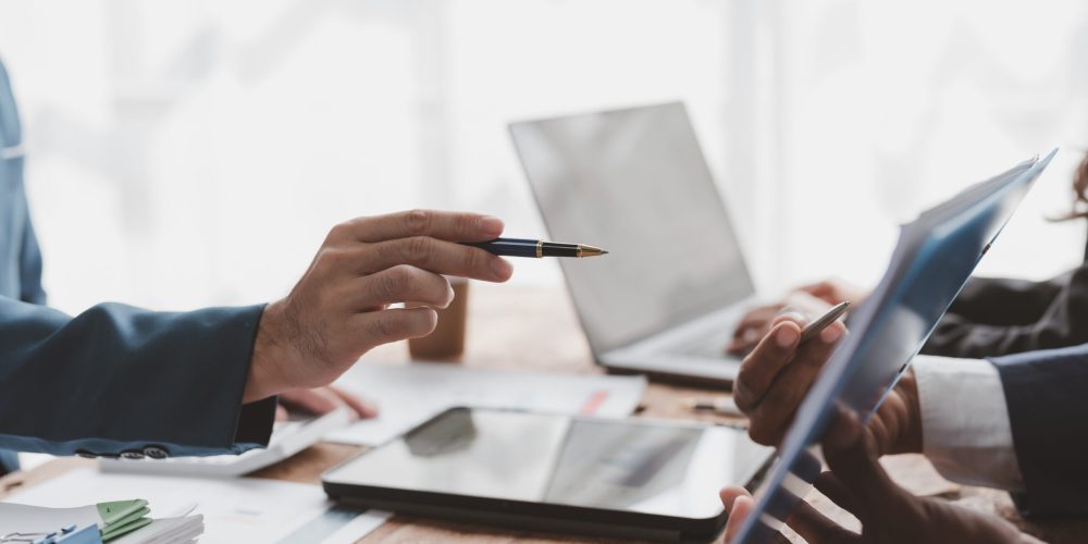 Business people, teamwork and meeting for strategy, planning or corporate brainstorming discussion at office. Business people meeting explaining the financial graph data and marketing plan.